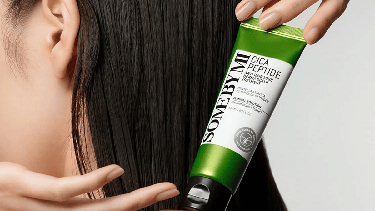 Person applicerar SOME BY MI Cica Peptide Anti Hair Loss Derma Scalp Treatment i långt mörkt hår med fokus på hårbottenvård och motverkan av håravfall.