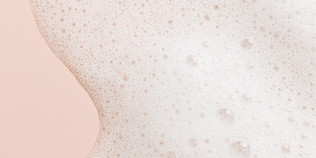 Bilden visar en rosa bakgrund vita bubblor och skum.
