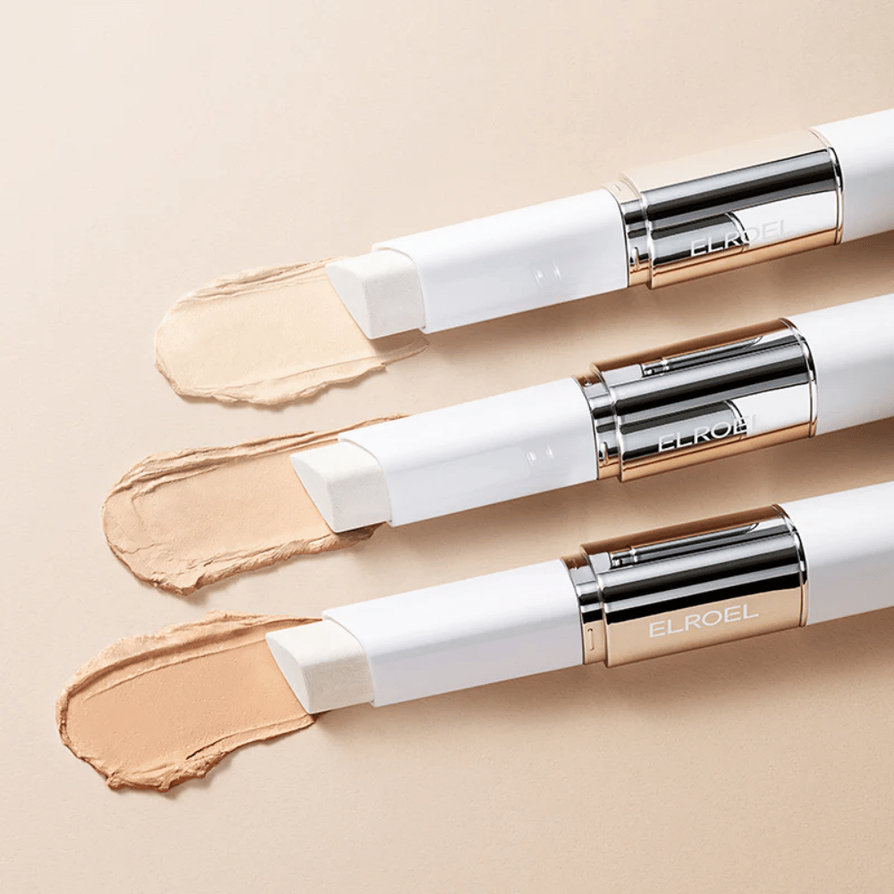ELROEL Blanc Cover Cream Stick concealer sisäänrakennetulla harjalla, useita tikkuja vierekkäin näyttäen tuotteen designin ja levityksen.
