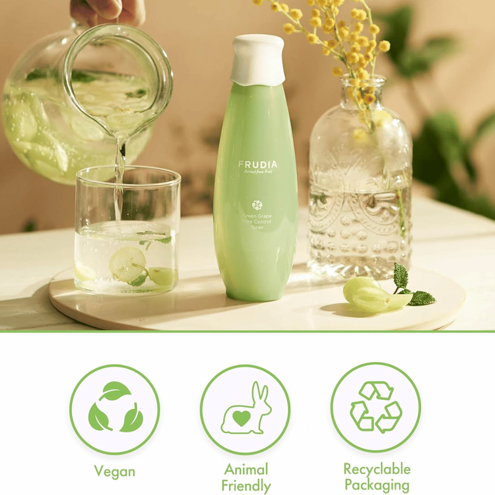 Frudia Green Grape Pore Control Toner luonnollisessa ympäristössä vihreiden rypäleiden ja veden kanssa, jotka symboloivat raikasta huokoshoitoa, kosteutusta ja tasapainoista ihoa vegaanisella korealaisella ihonhoidolla.