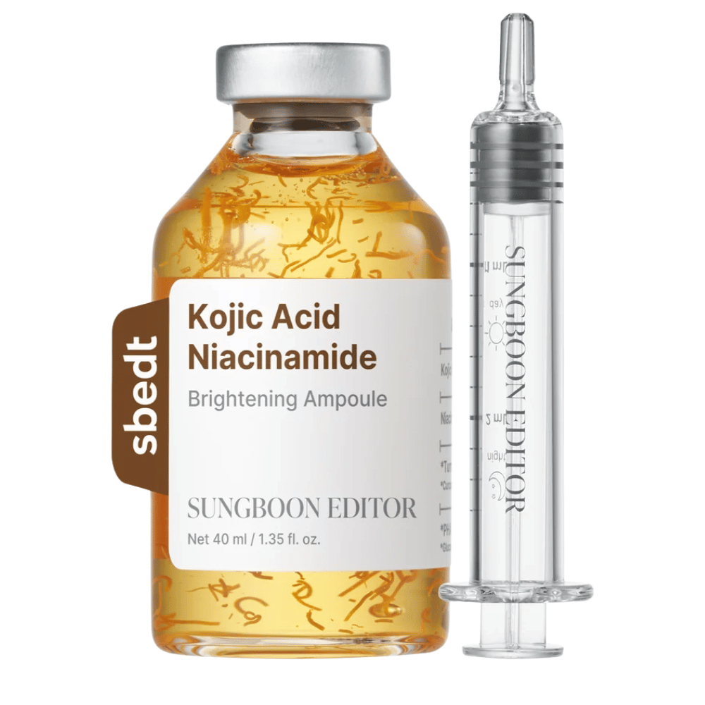7. SUNGBOON EDITOR Kojic Acid Niacinamide Brightening Ampoule 40 ml – kultainen seerumipullo, jossa näkyviä aktiivisia säikeitä ja läpinäkyvä applikaattori valkoista taustaa vasten