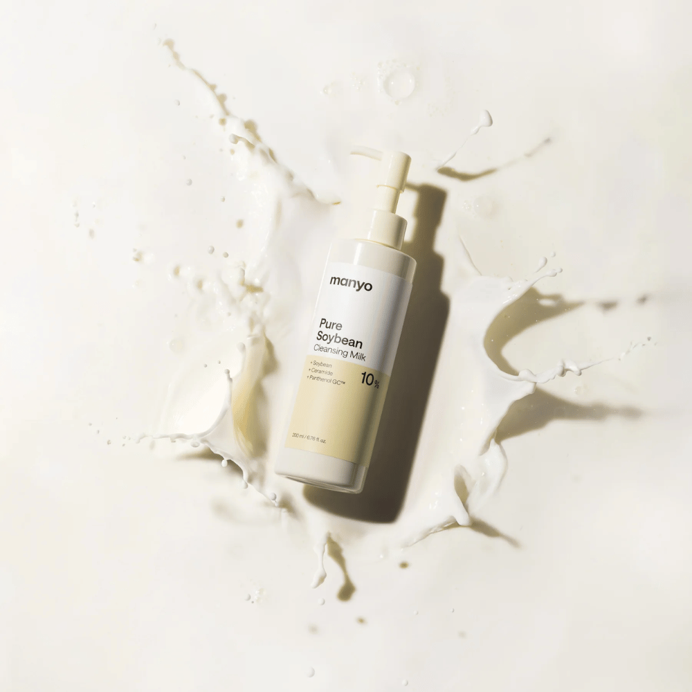 1. Ma:nyo Pure Soybean Cleansing Milk – mieto puhdistusmaito soijalla pumppupullossa, jota ympäröivät maitoroiskeet vaaleaa taustaa vasten