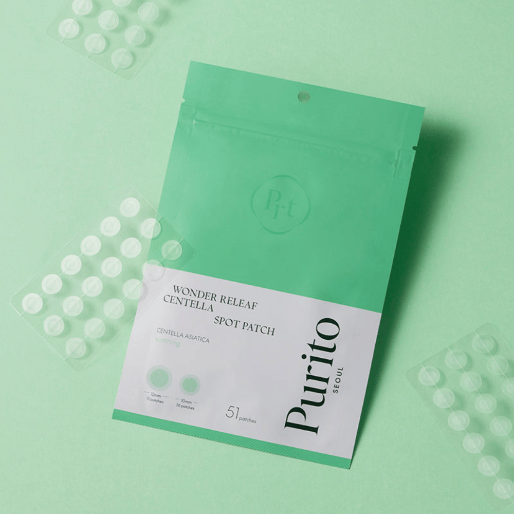 Purito Wonder Releaf Centella Spot Patch vihreällä taustalla näkyvillä laastariarkeilla, rauhoittavat aknelaastarit, jotka vähentävät punoitusta ja suojaavat epäpuhtauksilta.